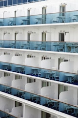 Close-up of a cruise ship balcony with chairs and railing.