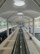 A modern airport terminal with travelers moving through sleek architecture.
