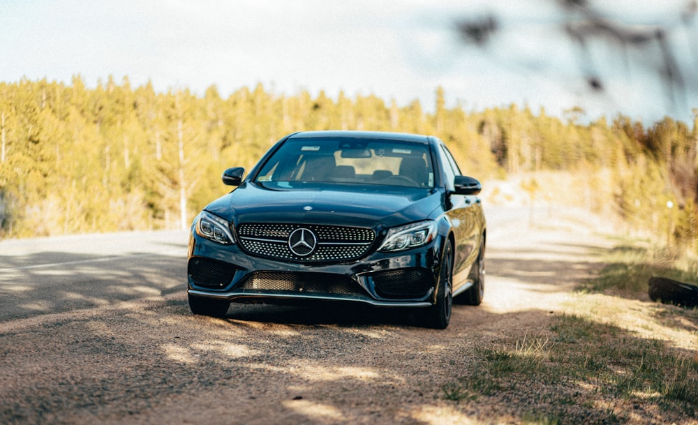 black mercedes benz c class on dirt road during daytime