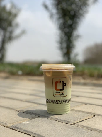 Close-up of a Fiercenest branded insulated tumbler filled with a refreshing drink on a game day picnic table.