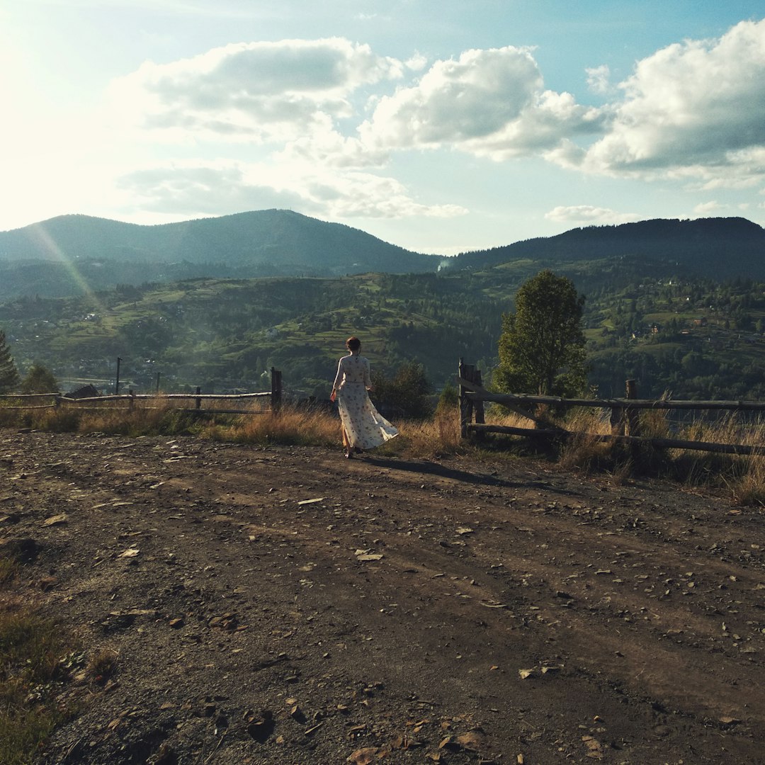 person walking on dirt road during daytime