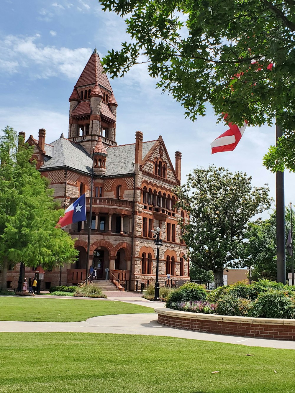 brown concrete building with flags on top during daytime