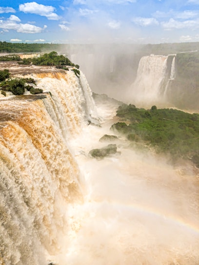 waterfalls on green grass field during daytime