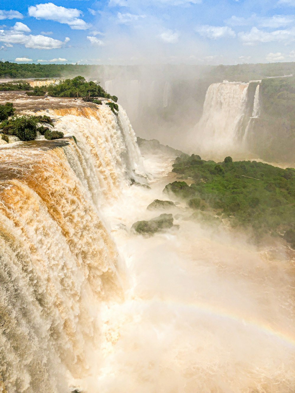 waterfalls on green grass field during daytime