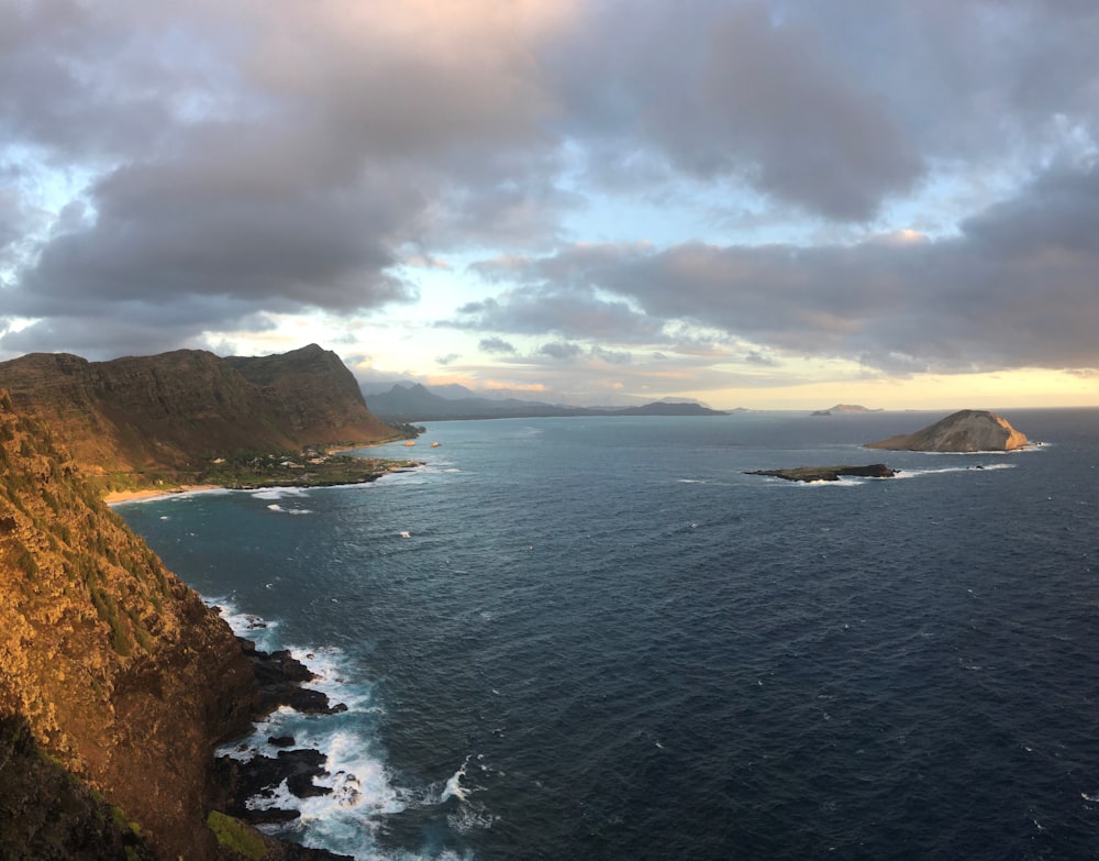 body of water near mountain during daytime