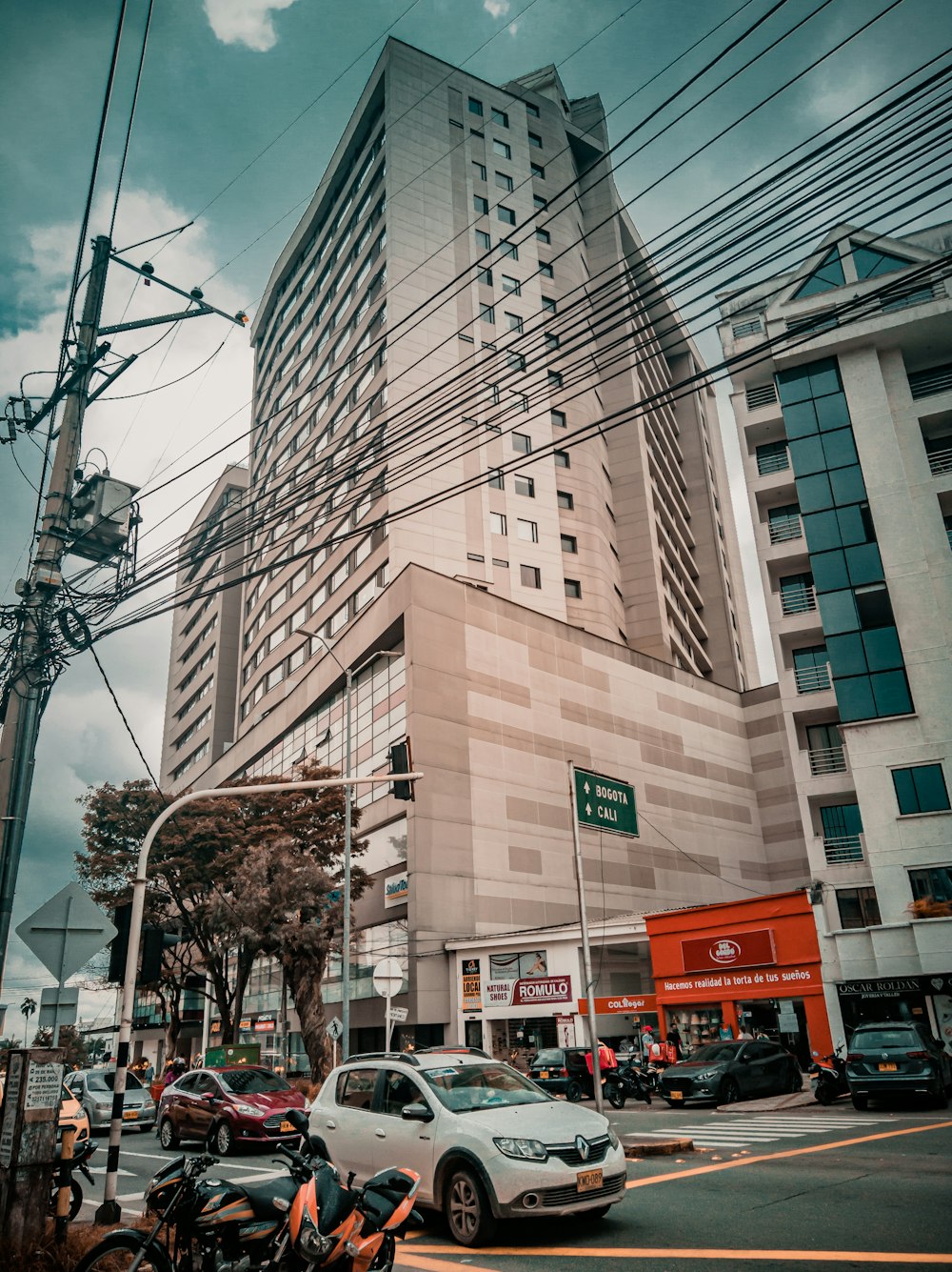 cars parked beside brown concrete building during daytime