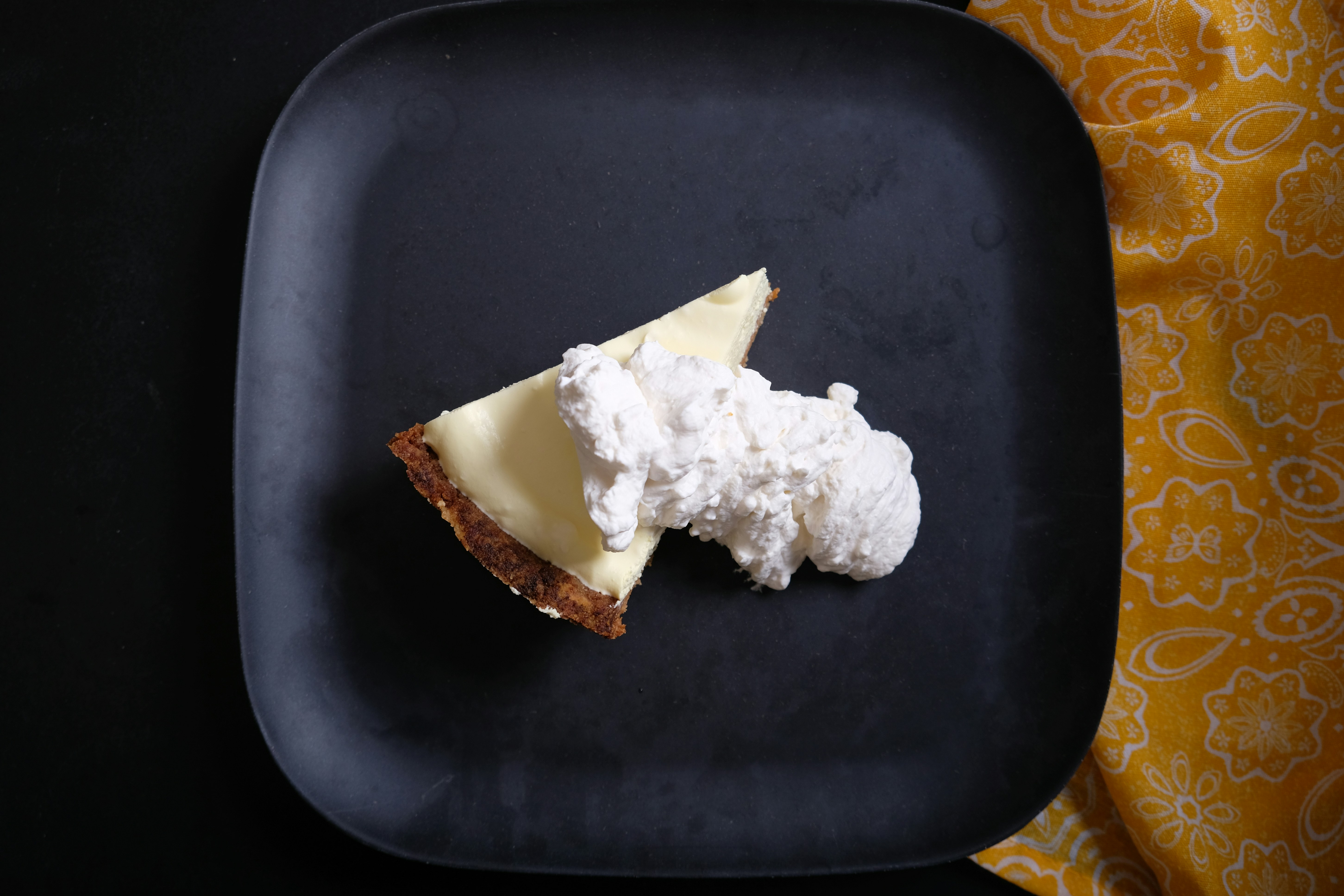 pie with whippedcream on a black plate