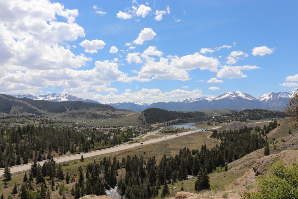 green trees and mountains under blue sky and white clouds during daytime