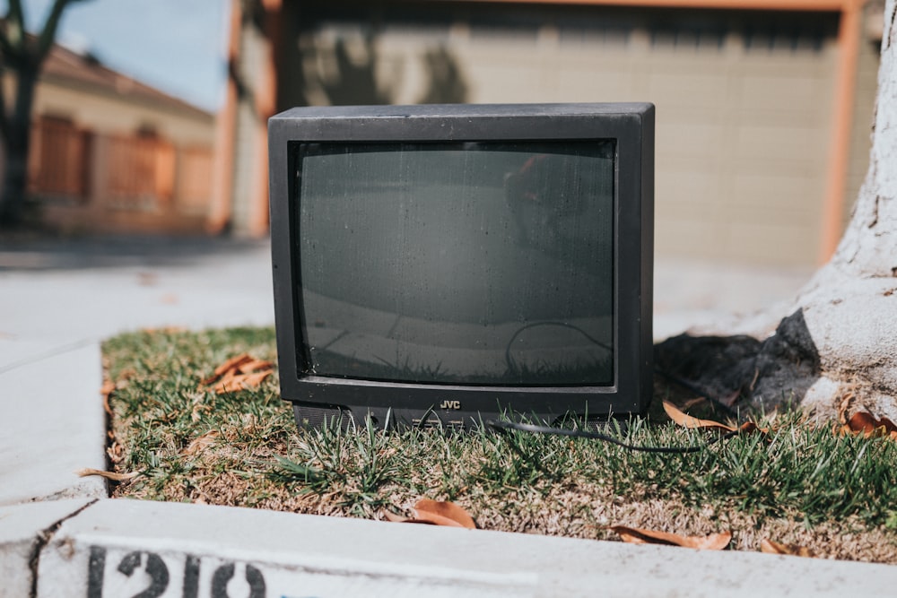 black crt tv on green grass during daytime