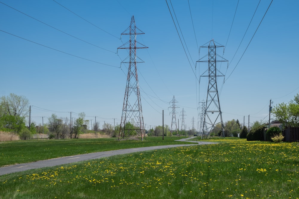 gray concrete road between green grass field under blue sky during daytime