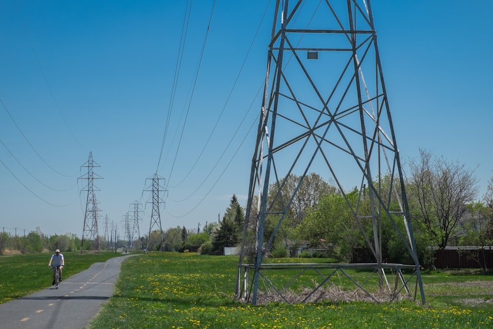 gray metal tower near green grass field under blue sky during daytime