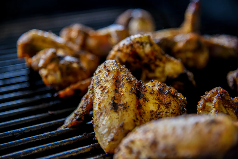 Juicy BBQ grilled chicken with golden caramelised skin and smoky glaze on the grill