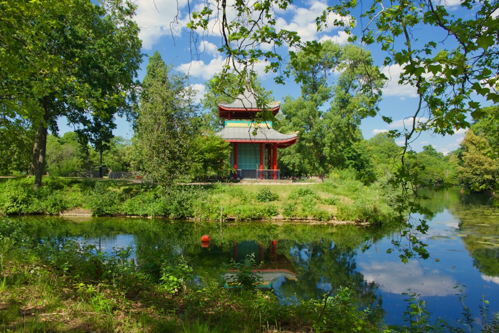 red and brown wooden house near green trees and lake during daytime