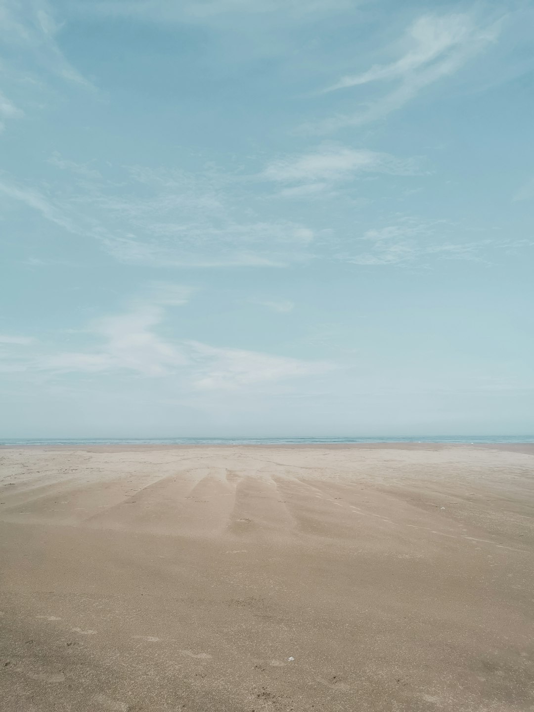 brown sand near body of water during daytime