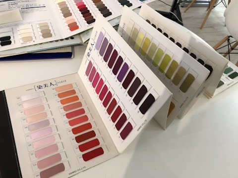 Close-up of hands arranging brand color swatches and typography samples on a table.