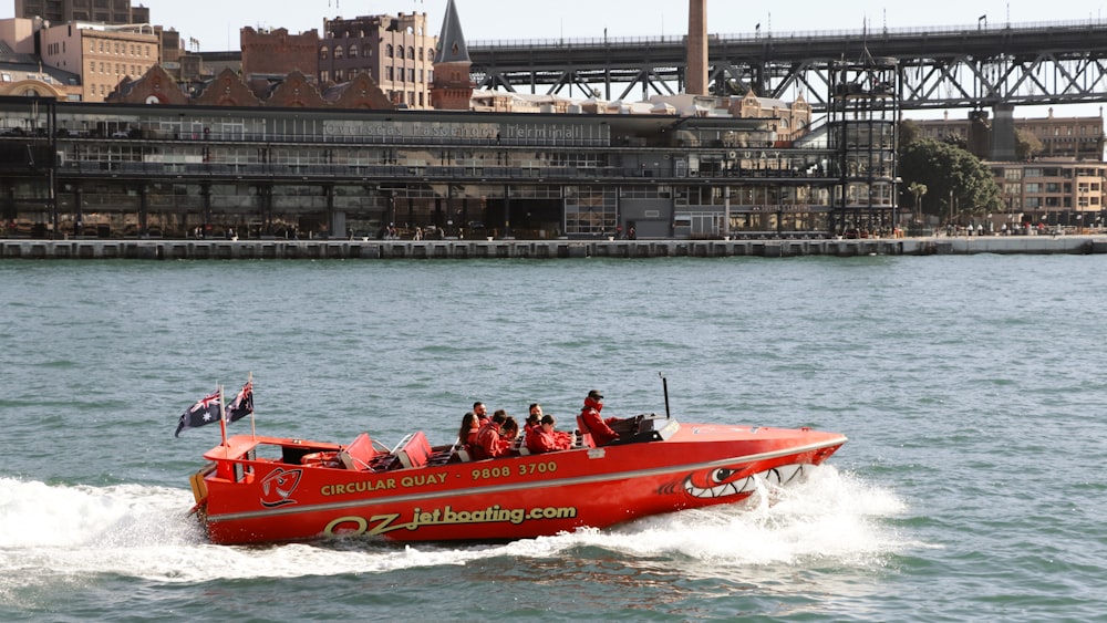 people riding red and white inflatable boat on water during daytime