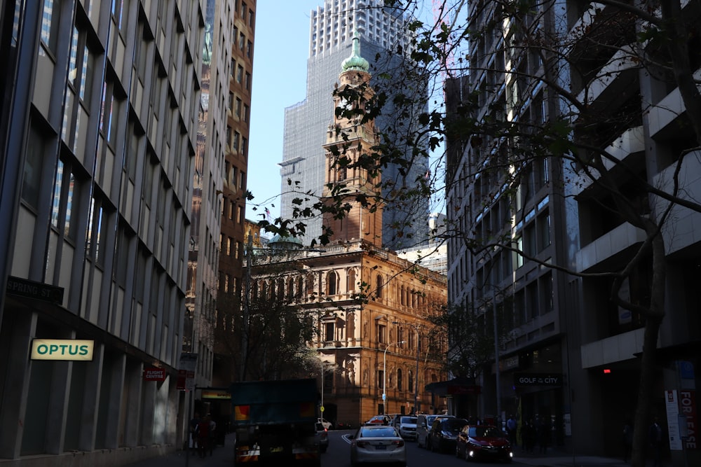 cars parked on side of the road near high rise buildings during daytime