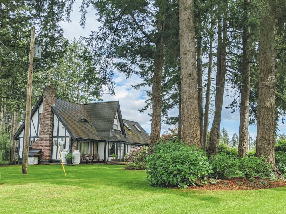 brown and gray house surrounded by green grass and trees during daytime