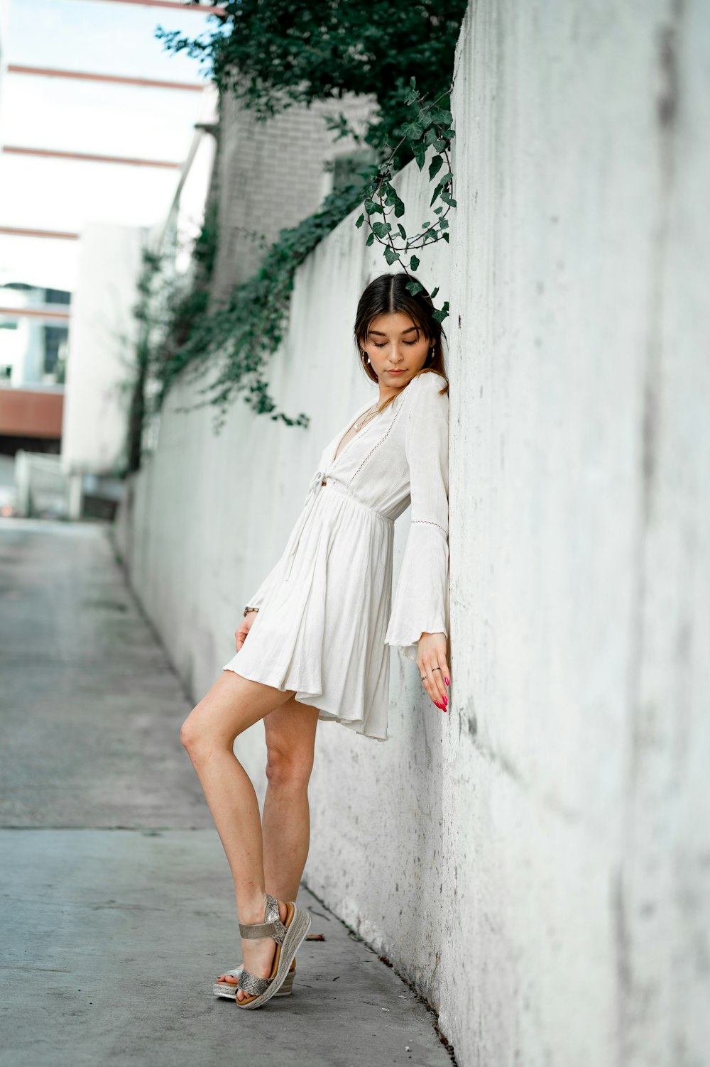 woman in white coat standing beside white wall