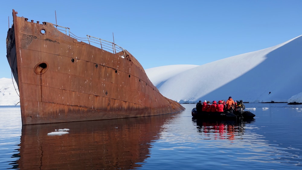 brown ship on calm water under blue sky during daytime