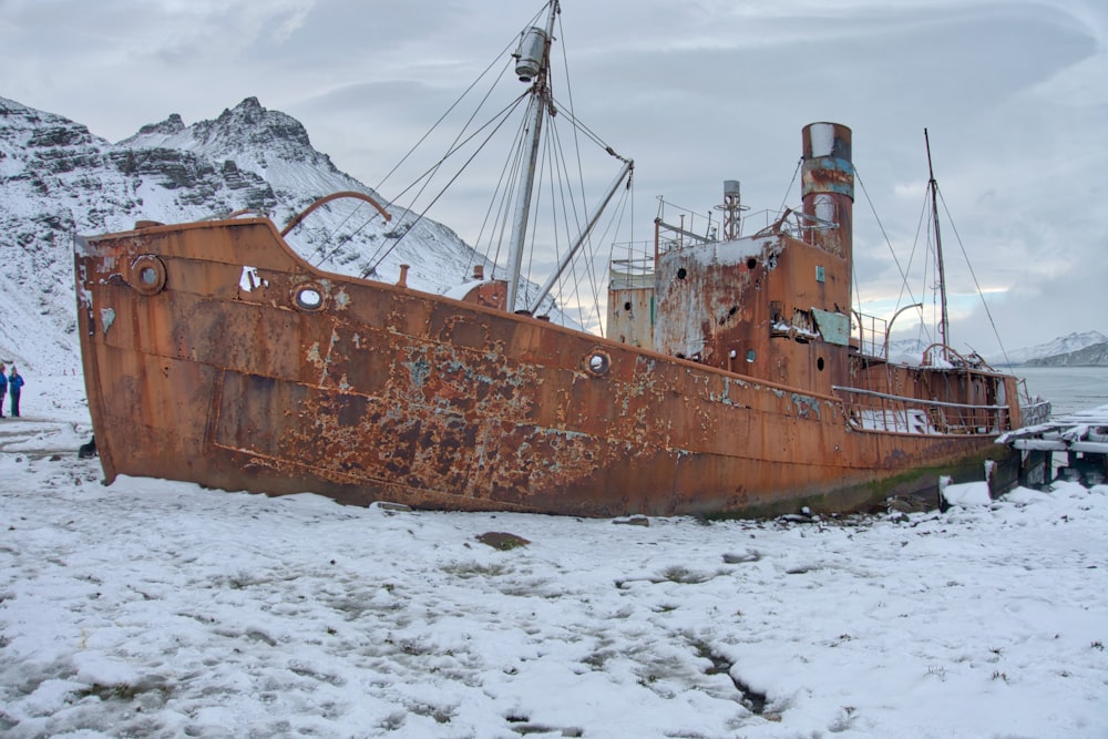brown ship on white snow covered ground during daytime