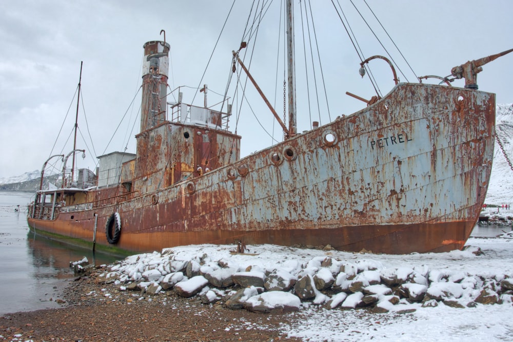 Braunes und weißes Schiff tagsüber auf braunem Sand