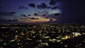 A cinematic shot of a city skyline at dusk with purple hues reflecting off glass buildings