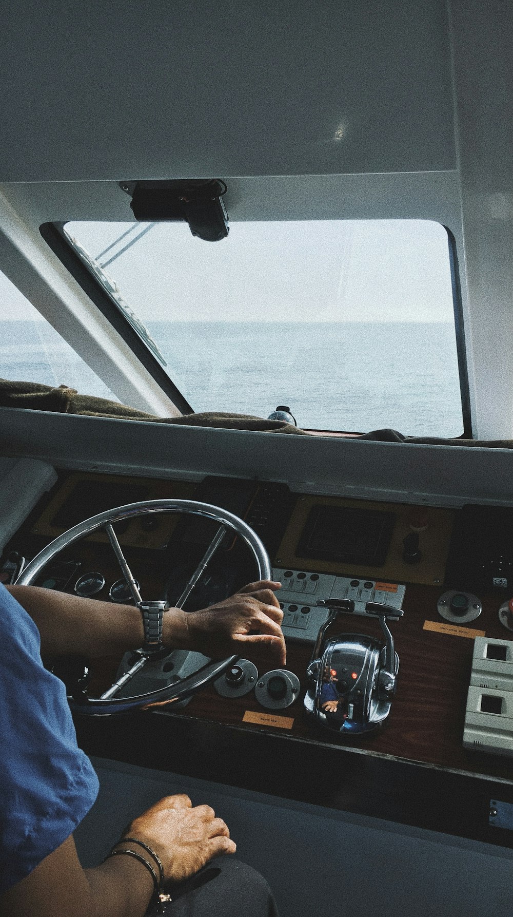 pessoa na camisa azul dirigindo um carro