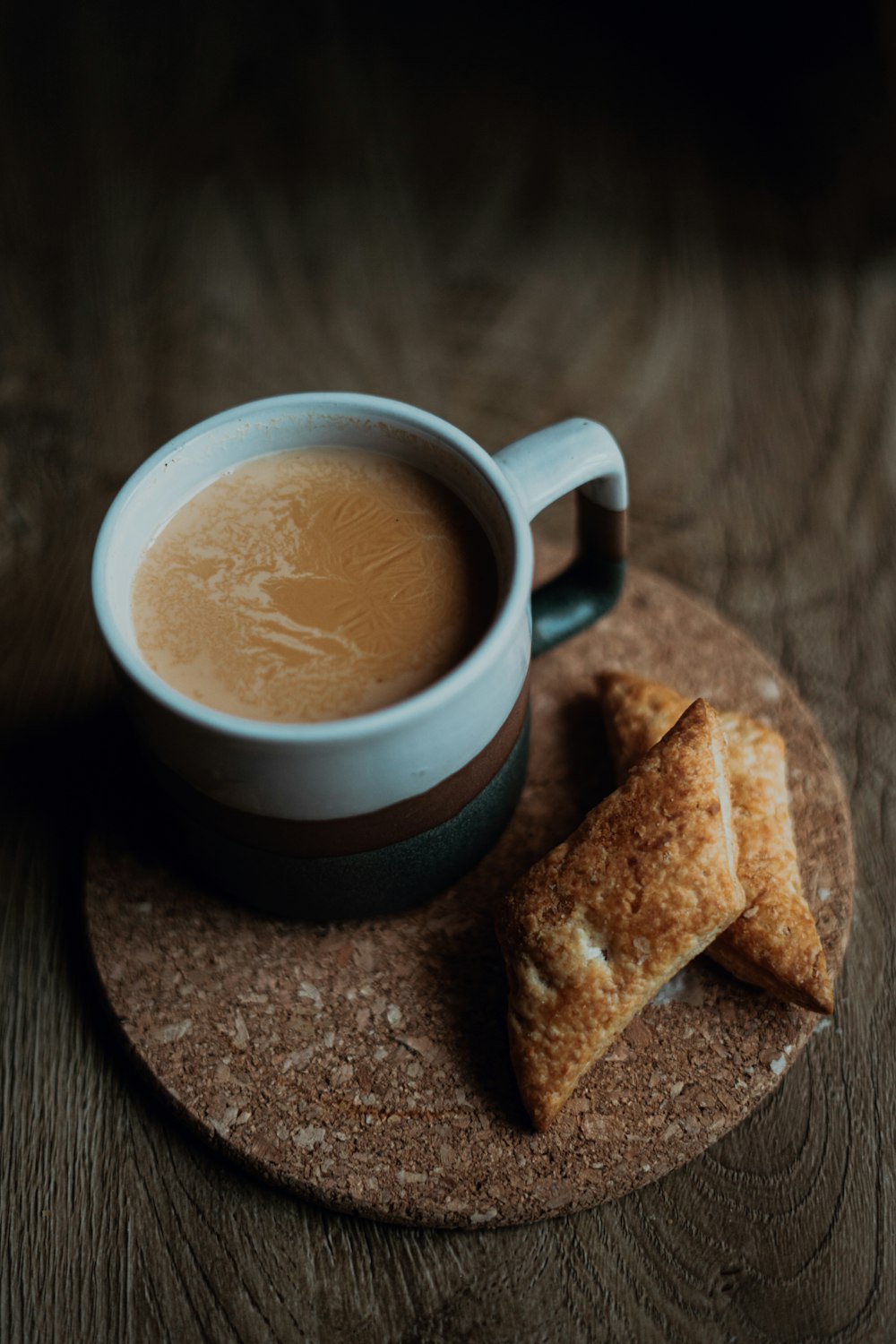 white and blue ceramic mug with brown liquid inside