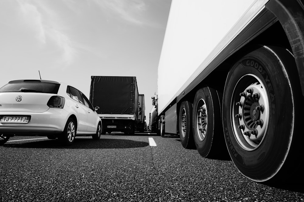 white coupe parked beside white truck