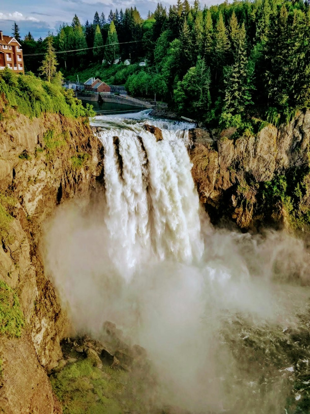 a view of a waterfall with a house in the background
