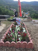 Close-up of a freshly cleaned grave adorned with vibrant seasonal flowers.