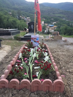 A close-up of a beautifully arranged floral tribute on a grave.