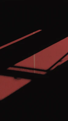 Elegant interplay of light and shadow on textured gold and red surfaces.