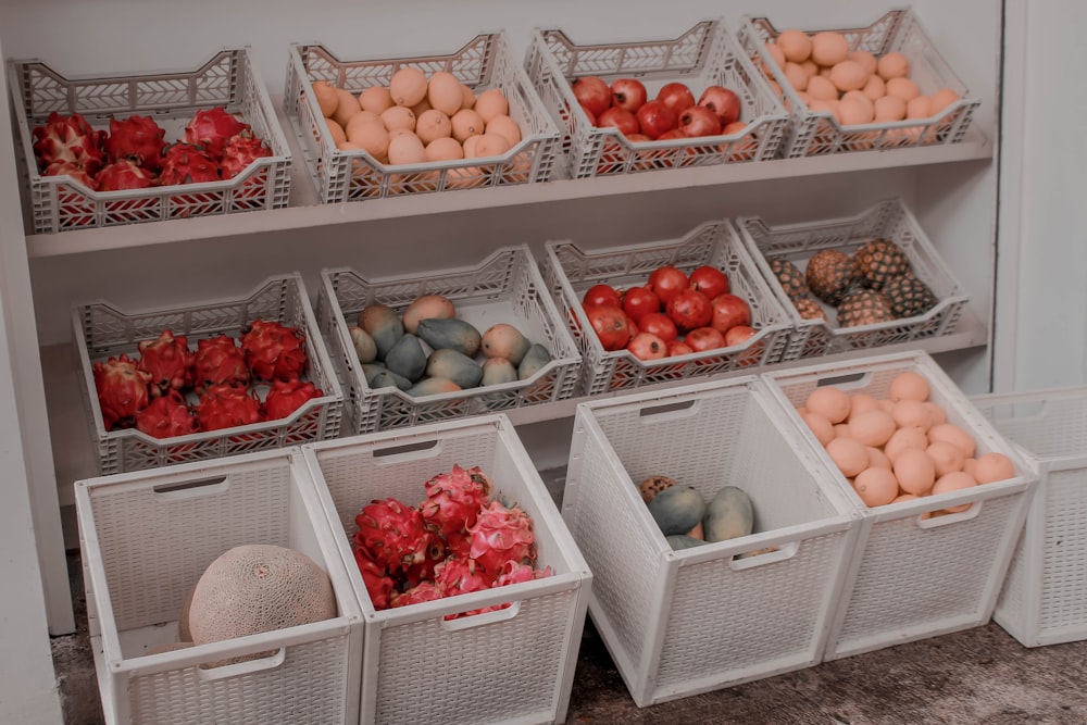 red and brown round fruits on white plastic crate