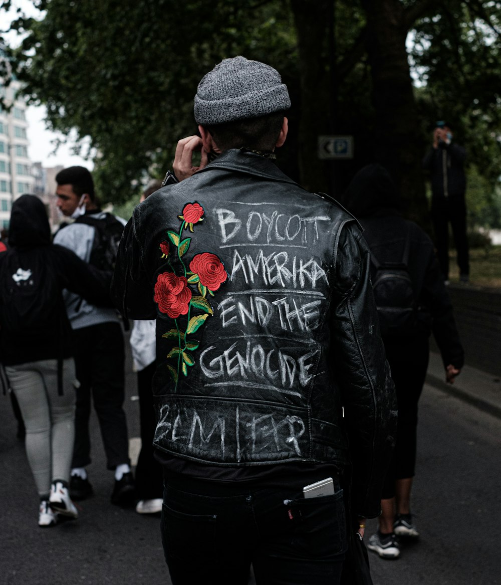 man in black and white crew neck t-shirt and black backpack walking on street during