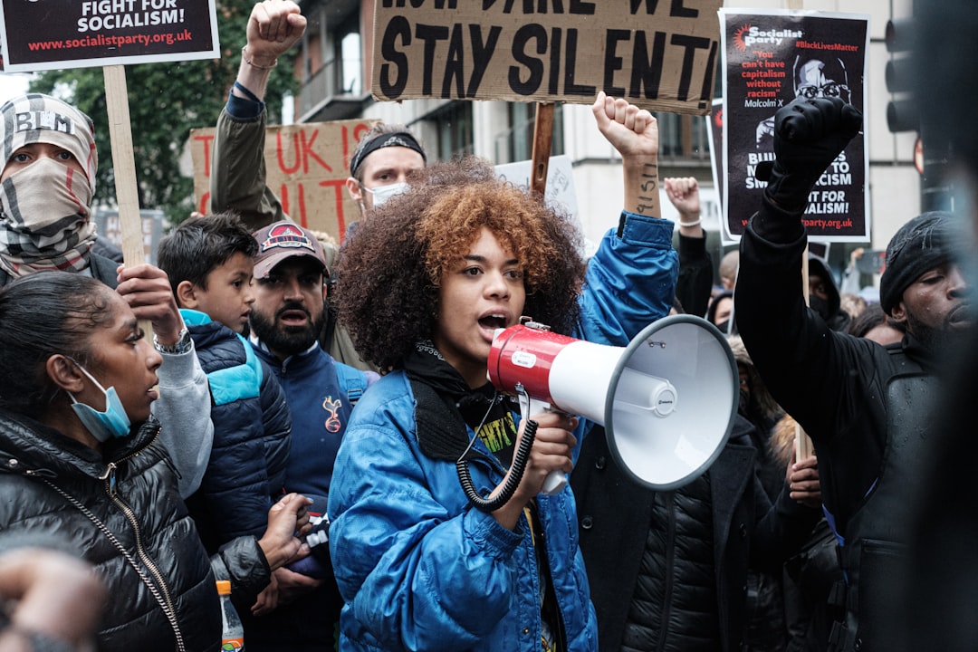 man in blue jacket holding red and white plastic cup, London Black Lives Matter Peaceful Protest from Hyde Park to Trafa