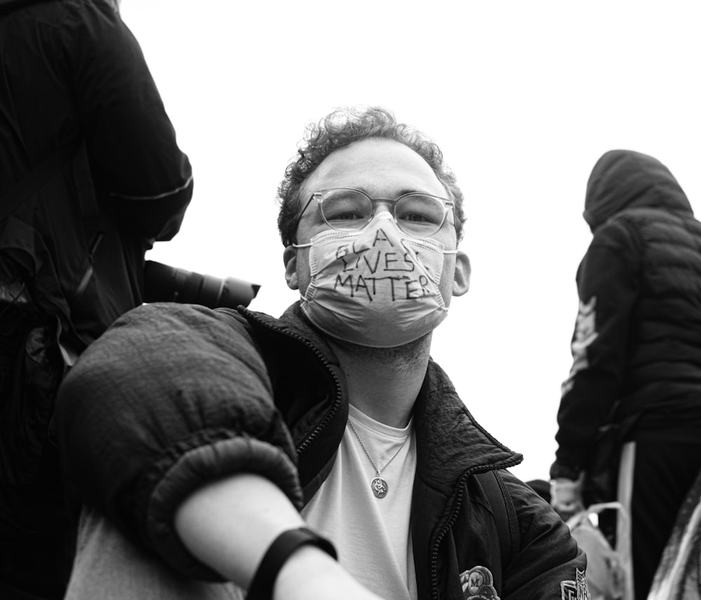 man in black jacket wearing white face mask