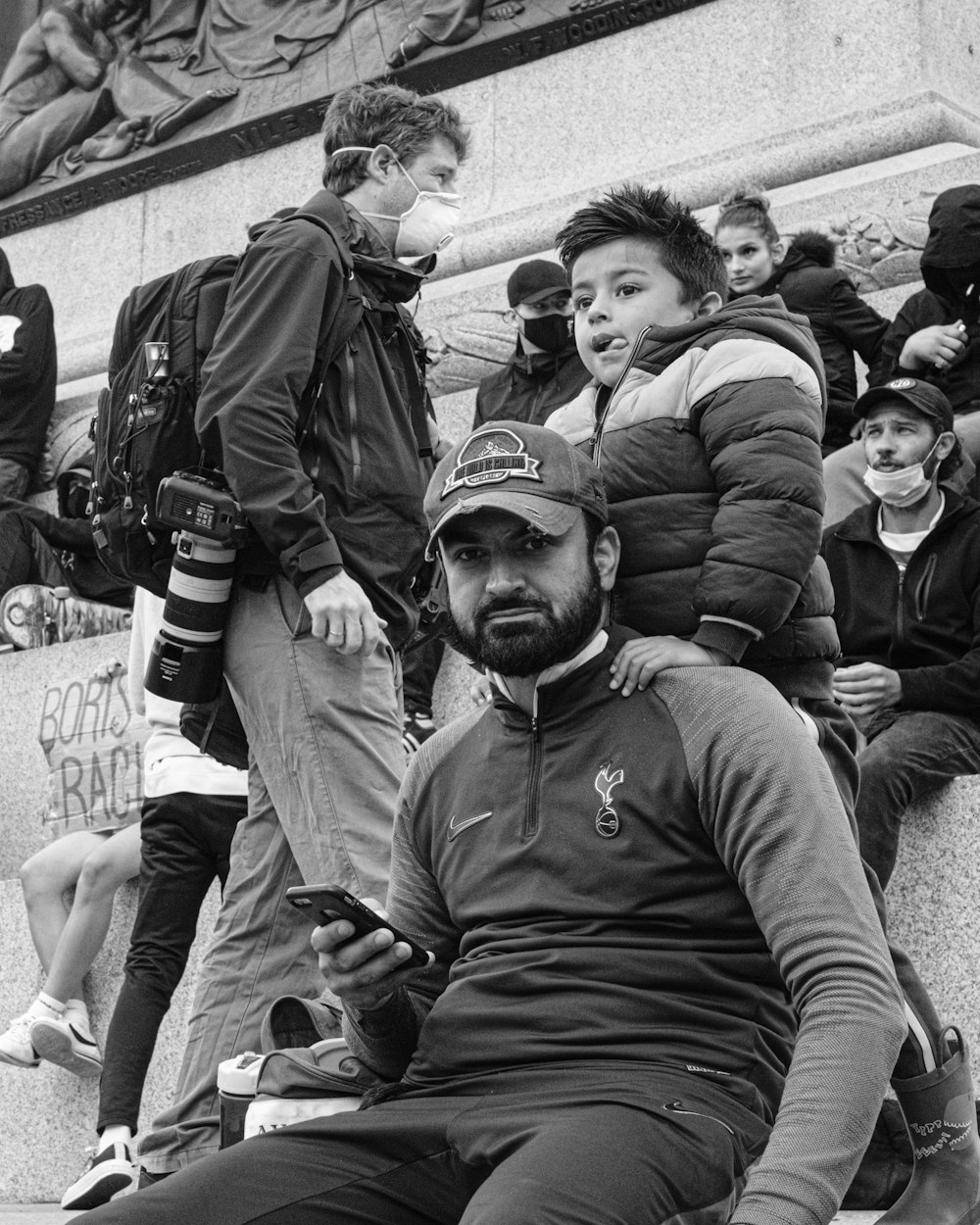 grayscale photo of man in hoodie sitting beside man in jacket