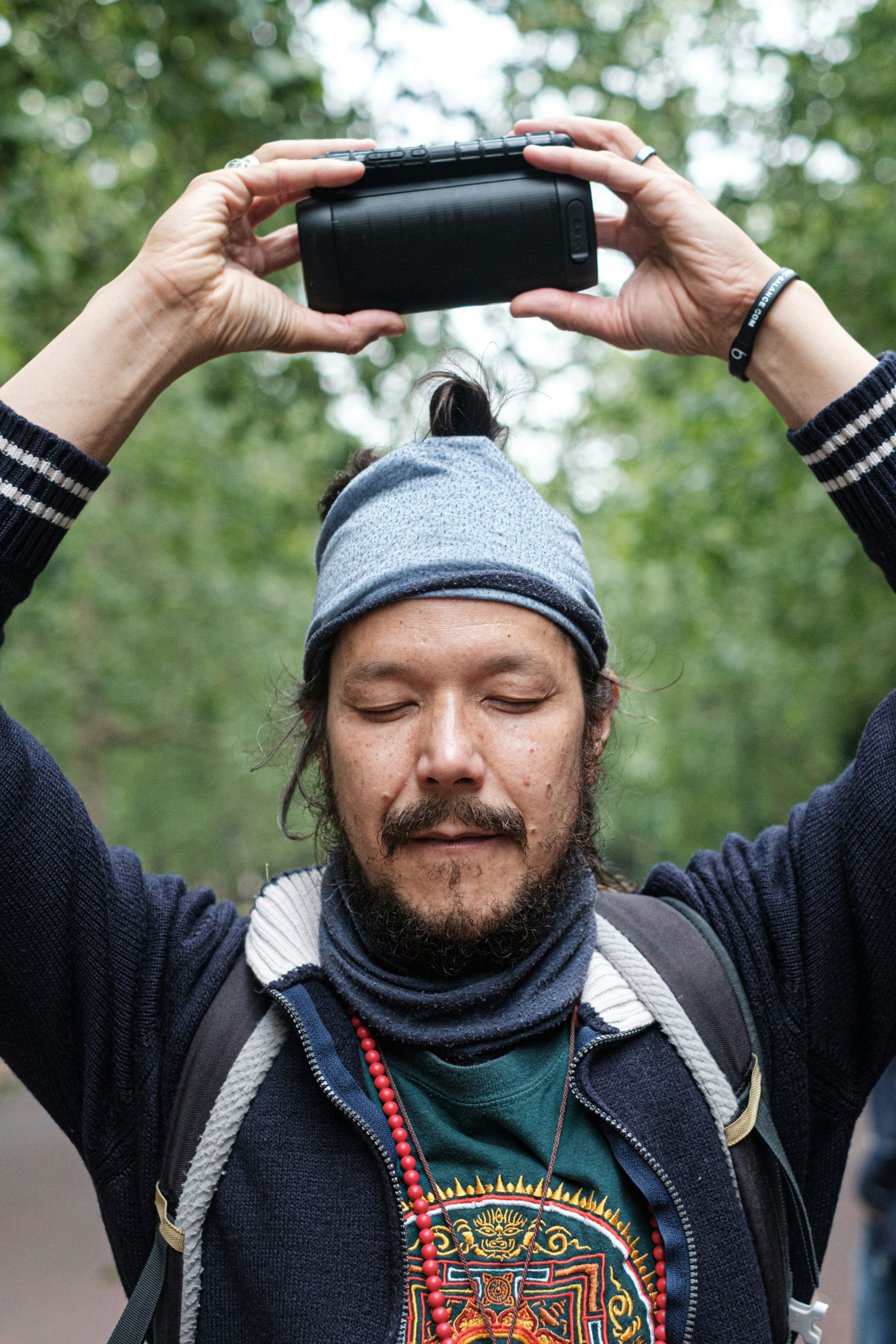 man in black and white jacket holding black smartphone