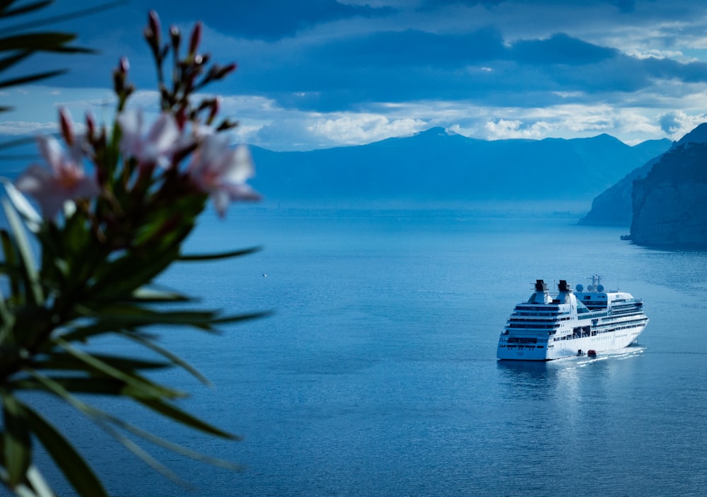 white ship on sea under blue sky and white clouds during daytime