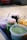 Several jars and containers filled with different colored foods, placed on a surface. The jars contain green, yellow, and purple ingredients with visible spoons for serving.
