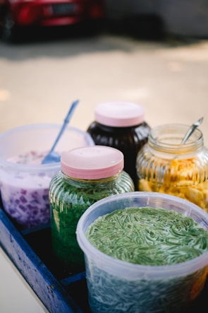 Colorful jars filled with various no-cook fillings arranged on a wooden table.
