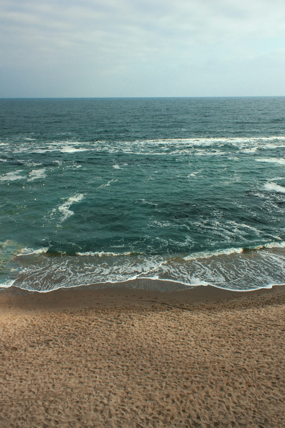 sea waves crashing on shore during daytime