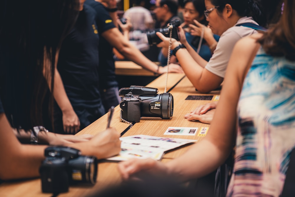 black dslr camera on brown wooden table