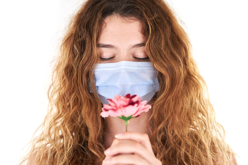 mujer con rosa rosa en la cara