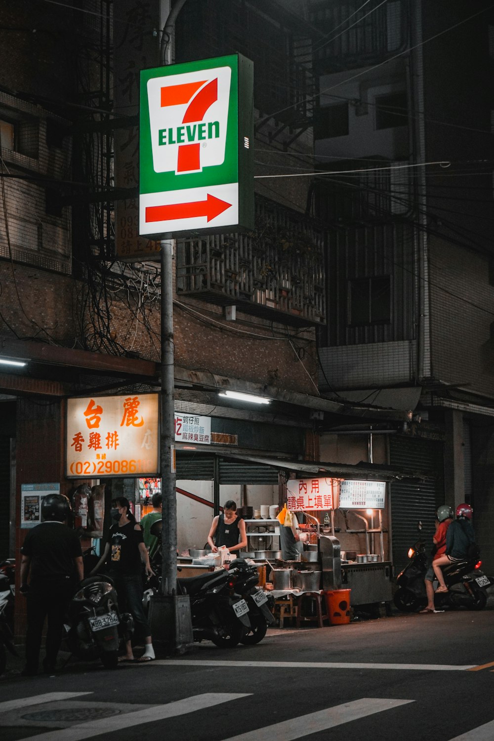 Personas sentadas en una motocicleta negra cerca de un edificio de hormigón gris durante el día