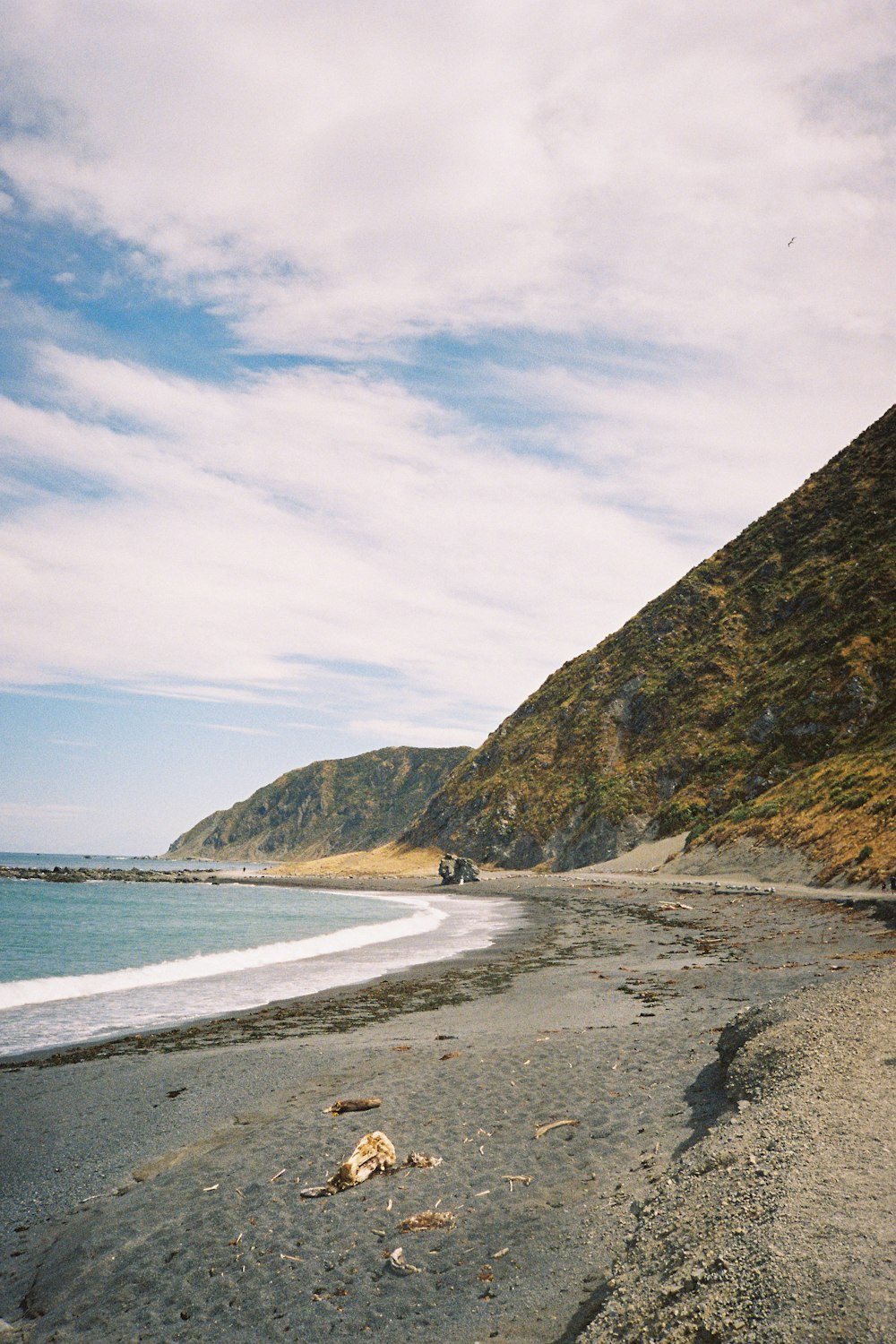 body of water near mountain under blue sky during daytime