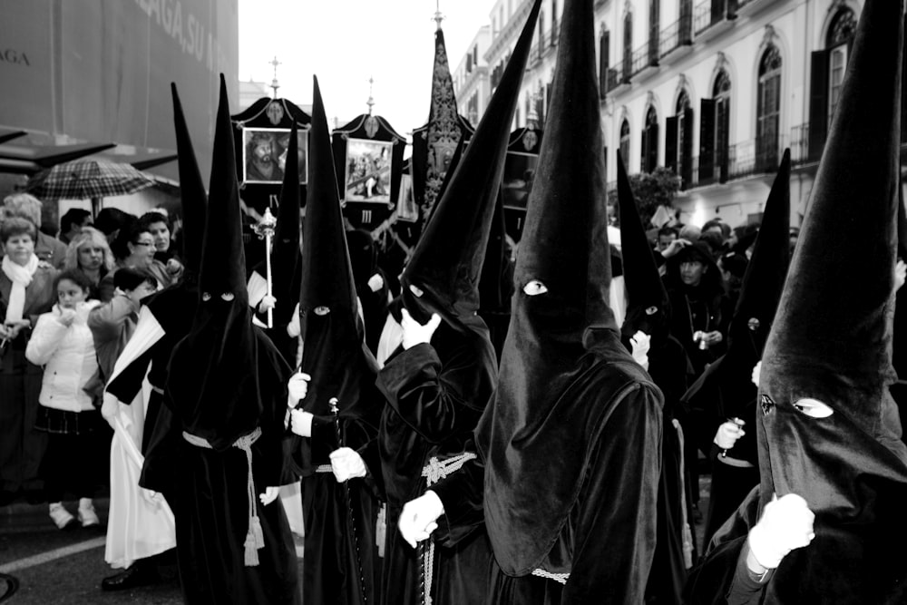 foto em tons de cinza de pessoas em manto preto
