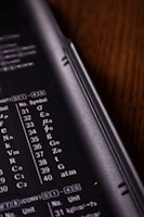 A close-up view of a calculator or electronic device with a black background. White alphanumeric symbols and numbers are visible, indicating various mathematical or scientific units.